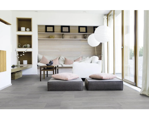 Helles Wohnzimmer mit grauer Diele, Sitzkissen, Sofa und Regalen