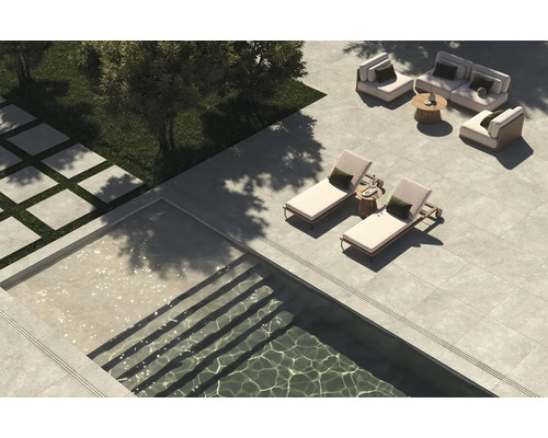 Blick auf eine Terrasse mit Steinfliesen, Pool und Sitzbereich