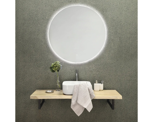 Badezimmergestaltung mit rundem Spiegel, Waschbecken, Armatur und Ablage