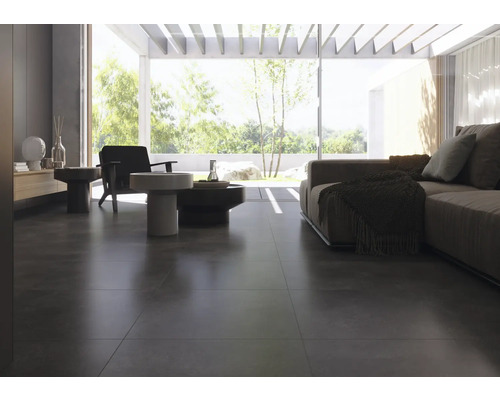 Heller Wohnraum mit dunklem Bodenfliesenbelag, Sofa und Sesseln