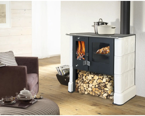 Kaminofen mit Holzfeuer, Backofen und Holzscheitlager in einem Wohnzimmer