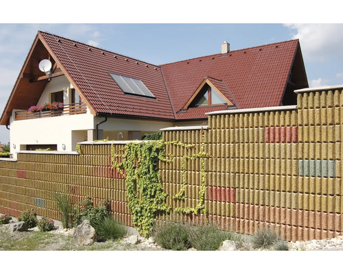Haus mit Grundstücksbegrenzung aus Betonsteinen und Bewuchs