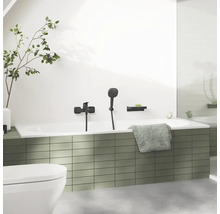 Badezimmer mit Badewanne, Armatur, Handbrause, Ablage und Handtuch