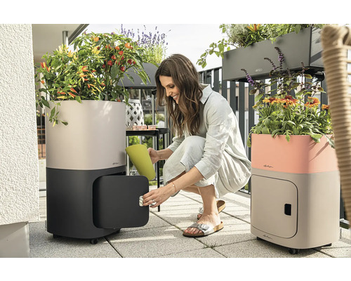 Balkonszene mit bepflanzten Pflanzgefäßen mit Bewässerungssystem und Stauraum.