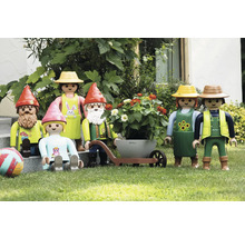 Szene mit Playmobil-Gartenfiguren, darunter Gartenzwerge, ein Paar mit Schubkarre und ein Kind auf einer Rasenfläche