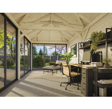 Innenansicht eines hellen Gartenhauses mit Büroecke und Lounge-Bereich