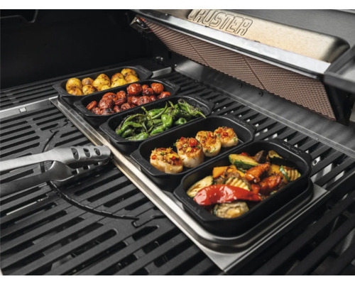 Verschiedene gegrillte Speisen in Schalen auf einem Grill