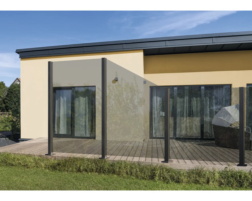 Terrasse mit Glaszaun und Holzfußboden vor einem Wohnhaus.