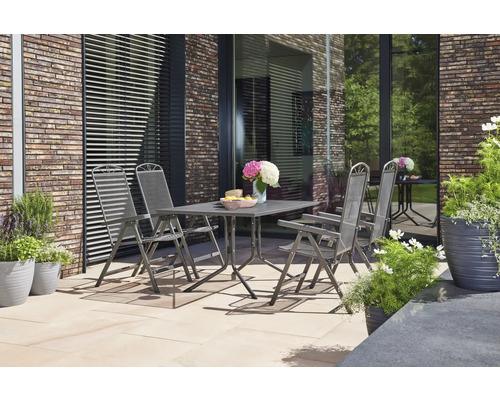 Gartenszene mit Gartentisch und vier Gartenstühlen auf einer Terrasse