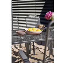 Gartenszene mit Tisch, Stühlen, Zitronenschale und Blumen