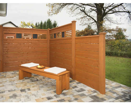 Holzsichtschutzwand mit Sitzbank und Kissen im Gartenbereich