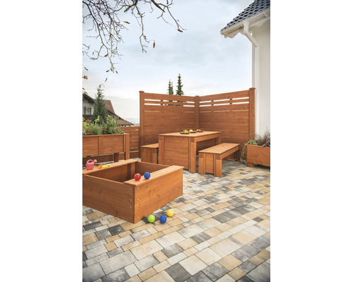 Gartenszene mit Holzzaun, Tisch mit Bänken, Sandkasten und Pflanzkästen