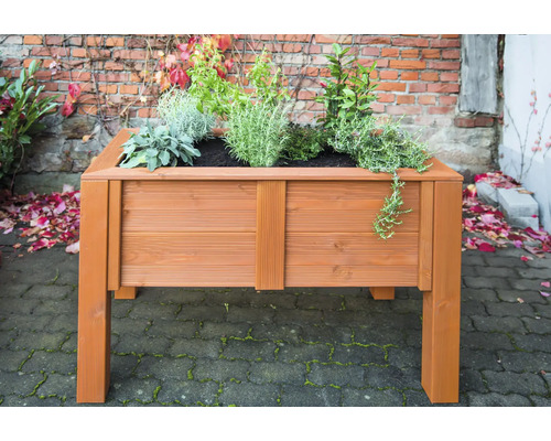 Hochbeet aus Holz mit Bepflanzung vor einer Backsteinmauer