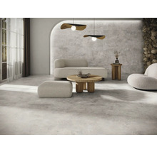 Heller Wohnraum mit Bodenfliesen, Sofa, Sessel und Couchtisch