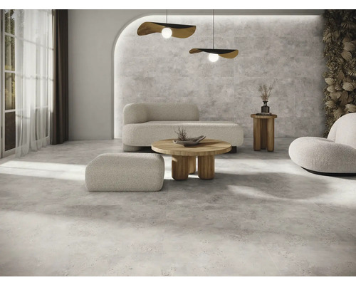 Heller Wohnraum mit Bodenfliesen, Sofa, Sessel und Couchtisch