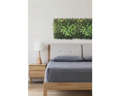 Schlafzimmer mit Bett, Nachttisch und künstlicher Pflanzenwanddekoration