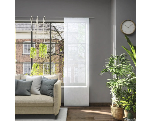 Wohnzimmer mit Sofa und transparentem Schiebevorhang am Fenster zur Lichtregulierung.