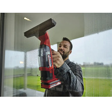 Mann reinigt Fenster mit einem Akku-Fenstersauger.