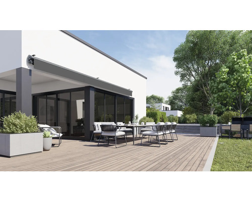 Terrasse mit Markise, Esstisch und Stühlen vor einem Wohnhaus