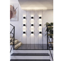 Szene mit Wandleuchten, Treppe und Zimmerpflanze.