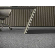 Detailansicht eines grauen Teppichbodens in einem Büro mit einem Schreibtisch und einem Bürostuhl.