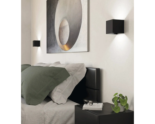 Schlafzimmer mit Bett, Nachttisch, Wandleuchten und Bild