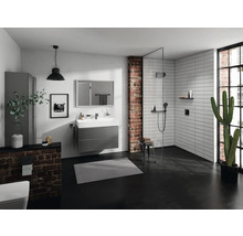 Modernes Badezimmer mit Dusche, Waschtisch und Toilette vor einer Ziegelwand