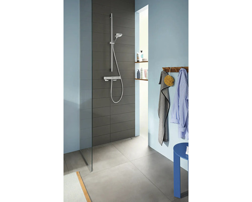 Badezimmer mit Dusche, Duscharmatur, Handtuch und Bademantel an einer Garderobe.