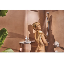 Frau unter der Dusche mit Brausegarnitur und Ablage