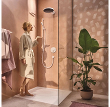 Helles Badezimmer mit Dusche, Duschwanne, Handtüchern und Zimmerpflanze für eine freundliche Atmosphäre.