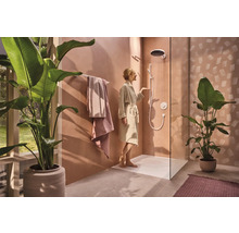 Helles Badezimmer mit ebenerdiger Dusche, Handtüchern und Zimmerpflanzen für ein modernes Ambiente.