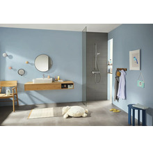 Helles Badezimmer mit Waschtisch, Spiegel, Dusche und Accessoires.