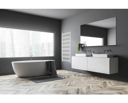 Helles Badezimmer mit Badewanne, Waschtisch mit zwei Waschbecken, Spiegel und Heizkörper