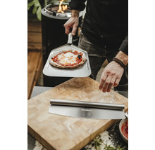 Szene mit Pizza auf Pizzaschieber, Pizzaschneider und Schneidebrett