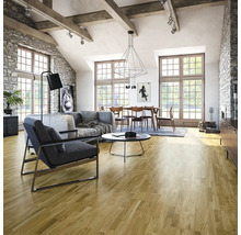 Heller Wohnraum mit Holzboden, Sofa, Sessel und Esstisch unter einer modernen Hängelampe.