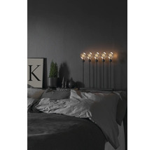 Dekoratives Schlafzimmer mit Bett, Nachttischlampe mit fünf Glühbirnen, Topfpflanze und Bild
