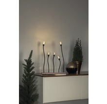 Dekorative Fensterbeleuchtung mit fünf Lampen und Pflanzen auf einem Sideboard.