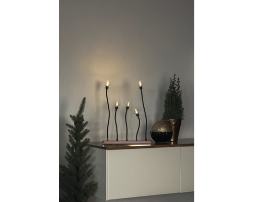Dekorative Fensterbeleuchtung mit fünf Lampen und Pflanzen auf einem Sideboard.