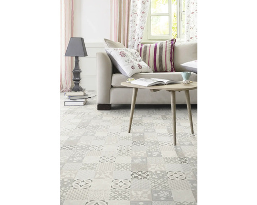 Helles Wohnzimmer mit Couch, Tisch, Lampe und Boden mit Fliesenmuster