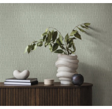 Wohnszene mit gemusterter Tapete, Anrichte, Büchern und Dekoration