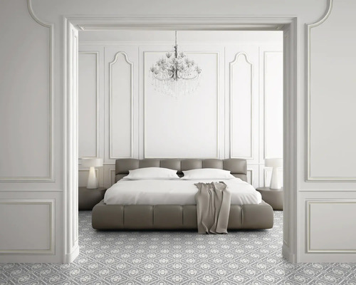 Schlafzimmer mit Bett, Nachttischen, Lampe, Kronleuchter und gemustertem Boden