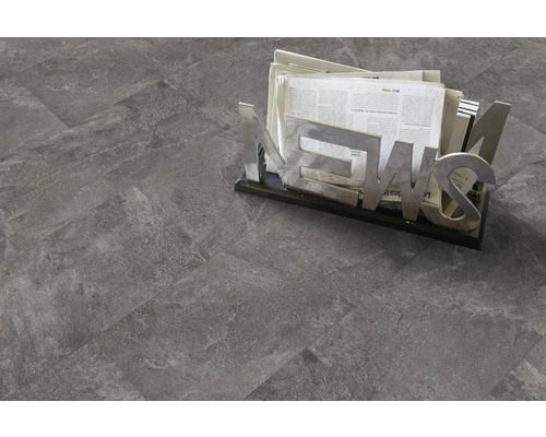 Grauer Fliesenboden mit Zeitungshalter.