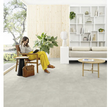 Wohnraum mit Frau im Sessel auf hellem Bodenbelag