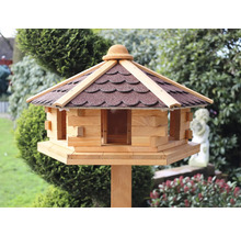 Vogelhaus aus Holz mit Dach auf einem Pfosten