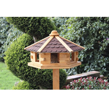 Vogelhaus mit Dach und Futtersilo auf einem Holzpfosten im Garten.