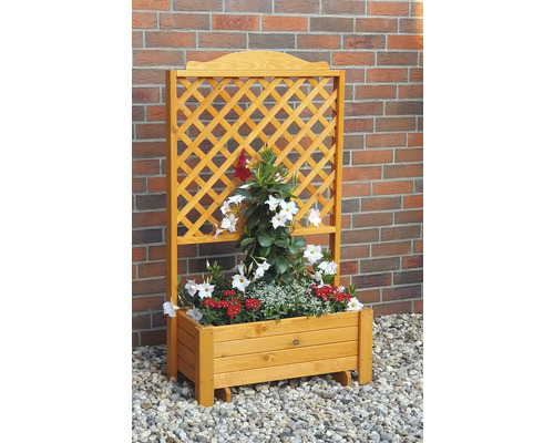 Blumenkasten aus Holz mit Rankgitter und Bepflanzung vor einer Ziegelwand