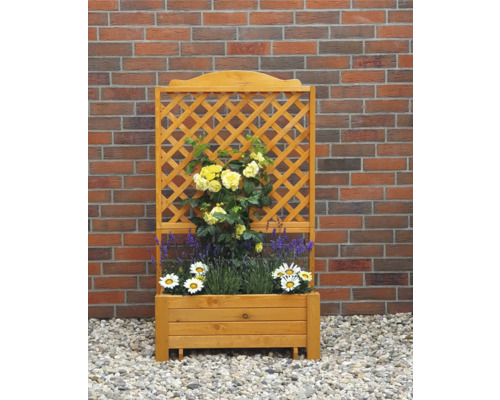 Blumenkasten aus Holz mit Rankgitter und Pflanzen vor einer Backsteinmauer