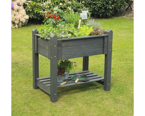 Hochbeet aus Holz mit Kräutern und Gemüse im Garten