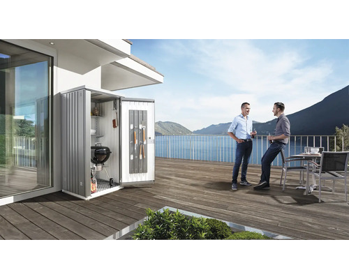 Geräteschrank mit Grill und Zubehör auf einer Terrasse mit zwei Personen und Seeblick.
