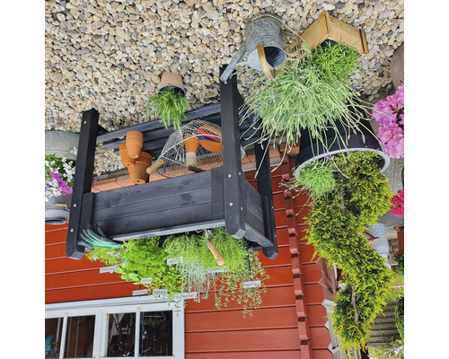 Gartenregal mit Pflanzen, Töpfen und Gartenzubehör im Außenbereich.